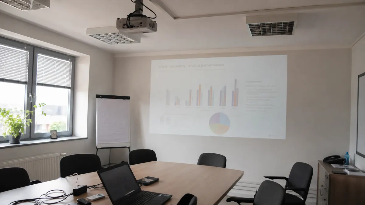 Słabo widoczny obraz z projektora w sali konferencyjnej podczas prezentacji biznesowej